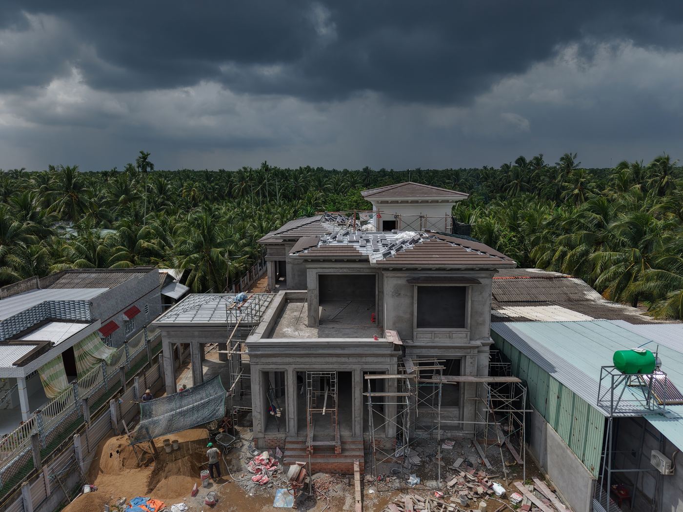 Mặt tiền villa đang thi công với giàn giáo và vật liệu xây dựng